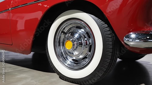 Detailed view of a red classic car wheel and fender.