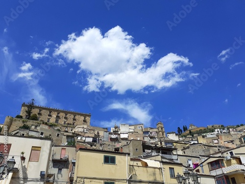 Foto Veduta panoramica di Leonforte, piccole case abbarbicate sulla colline e in alto la mole del palazzo Branciforti