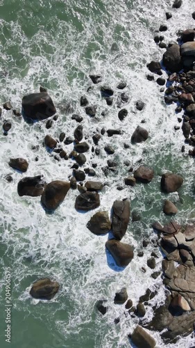 Tropical beach with waves hitting on the rocks at Brazil