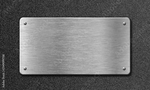 Brushed metal plaque with rivets on textured dark background for industrial signage concept