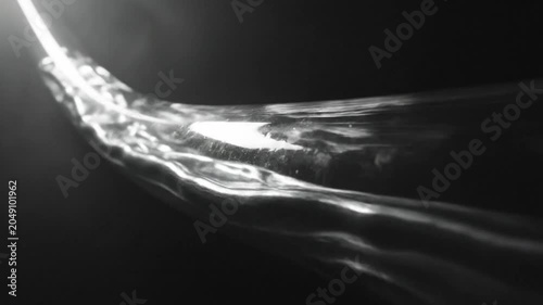 Abstract Close-up of Flowing Water Against a Black Background Displaying Calm Movement and Reflection