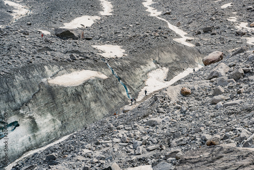 Foto Mountaineers hiking across glacier and rocky mountain terrain