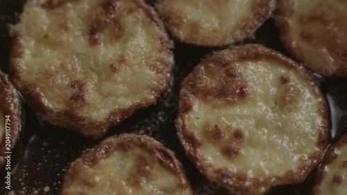Zucchini, cut into rings, are fried in oil in a pan