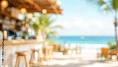 blurred view of a tropical beach bar by the ocean during a sunny day. Summer vacation travel background with wooden stools and palm tree. Relaxing coastal scenery for holiday concept