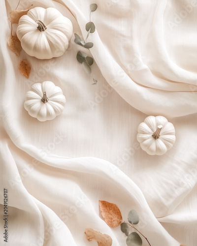 Neutral Autumn Background with White Pumpkins and Flowing Linen Fabric