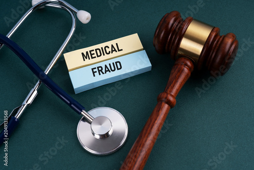 Medical fraud text with stethoscope and gavel on green background