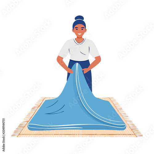 Woman folding a blue blanket on a rug