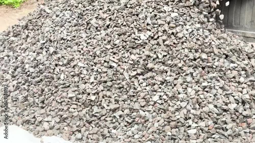 Truck unload crushed rocks. Dump truck unloads crushed stone from the body