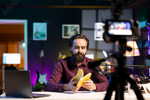 Photos Content creator in studio reviewing newly released hardcover book from publisher, unhappy with story