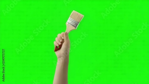 Closeup of a hand holding a paint brush against a green screen background, perfect for chroma key compositing and creative video editing projects 4k video