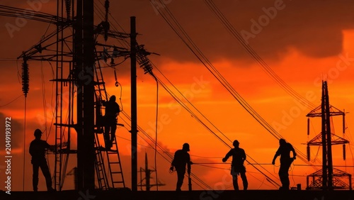 Electricians Working on Power Lines at Sunset