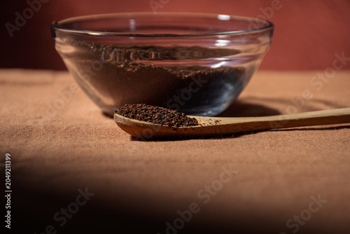 Close-up of a glass bowl containing roasted coffee beans.