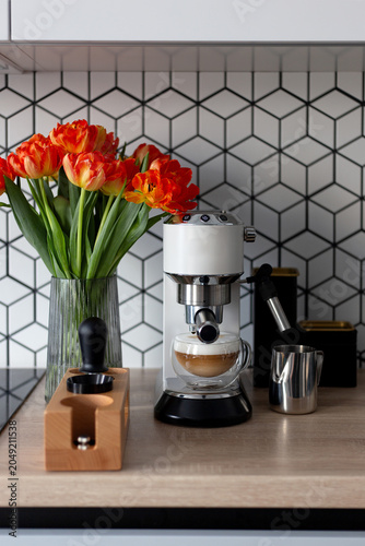 Obraz na plátně Modern white espresso machine with fresh latte coffee and tulips in the kitchen
