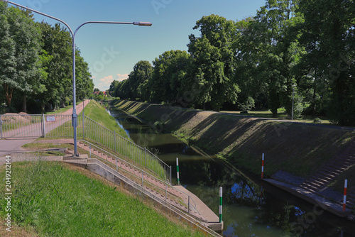 Blick entlang des baumbestandenen Kanals zur Schleuse mit Radweg und Spiegelung im Wasser, Merseburg, Saalekreis, Sachsen-Anhalt, Deutschland