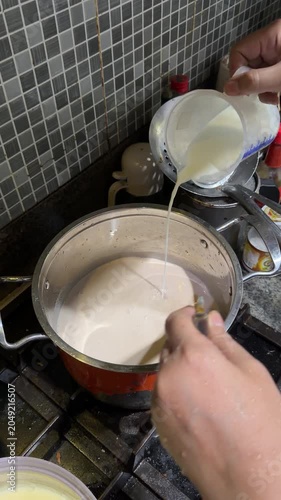Coconut milk liquid is poured into the bowl of chocolate cake mixture