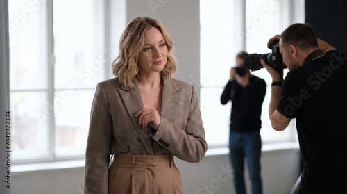 Professional studio photoshoot of a female model with photographer taking pictures