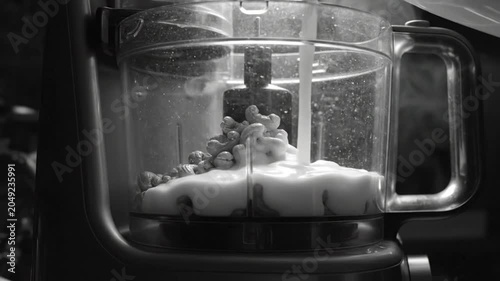 Black and white video of pouring milk over cashews into a food processor for a creamy, dairy-free, vegan base