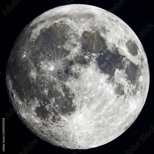 Detailed full moon with visible craters and plains. Detailed high resolution photo of the full moon in the dark night sky