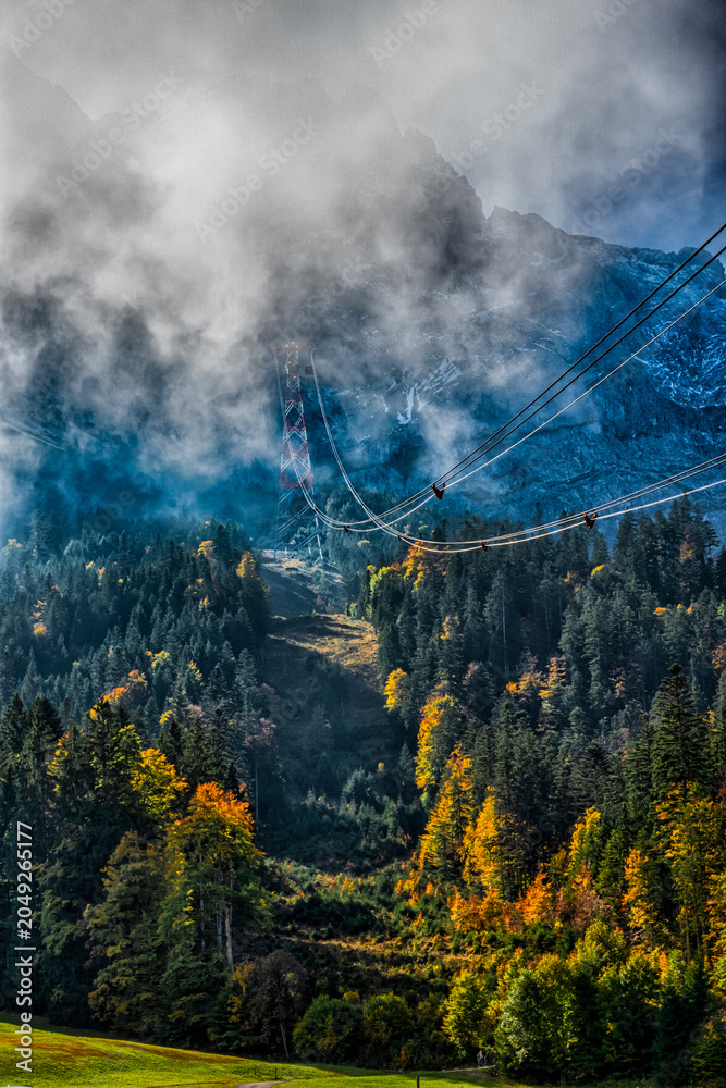 Fototapeta premium Zugspitze Cable Car Through Misty Alpine Forest