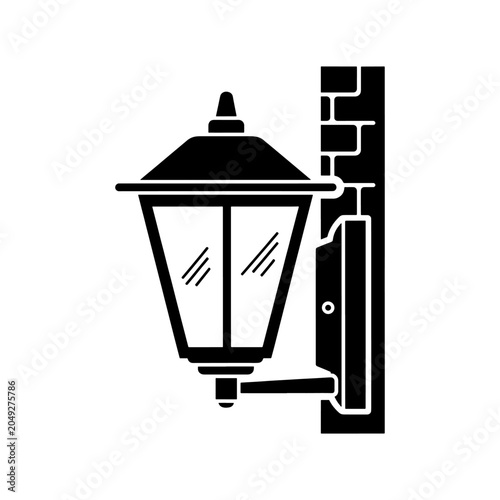 Photos A black silhouette of an ornate outdoor lamp affixed to a brick wall beautifully