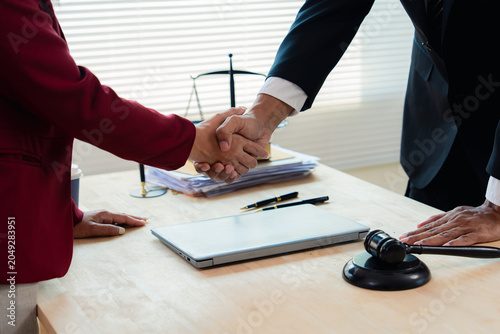 Tableau sur toile The emphasis is on close-up legal collaboration, with lawyers and clients shaking hands after signing a contract at the law firm