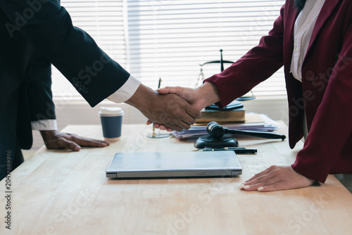 Photos The emphasis is on close-up legal collaboration, with lawyers and clients shaking hands after signing a contract at the law firm