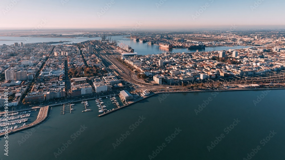 Obraz premium Aerial view of riverfront city with docks, bridges and skyline