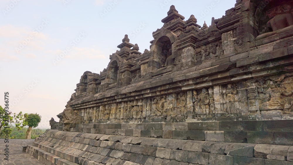 Fototapeta premium Majestic stone structure and relief walls of Borobudur Temple from a low angle corner perspective in Magelang, Central Java, Indonesia