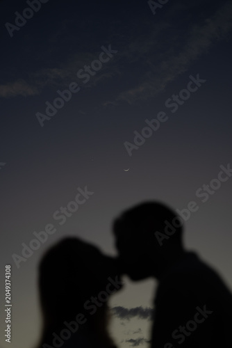 Couple kissing under the moon and venus