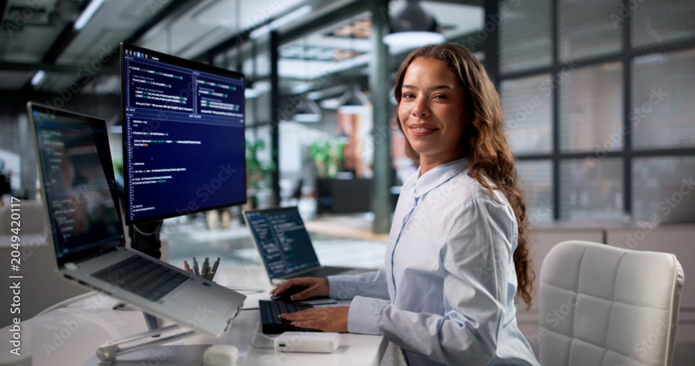 © Andrey Popov - Young Woman Coder Happily Typing New Software Code On Laptop