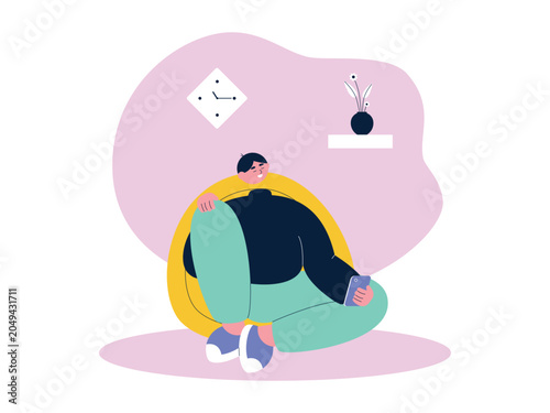 Foto A smiling man curled up in a yellow egg chair holding his phone, beneath a diamond clock and a shelf with a flower vase