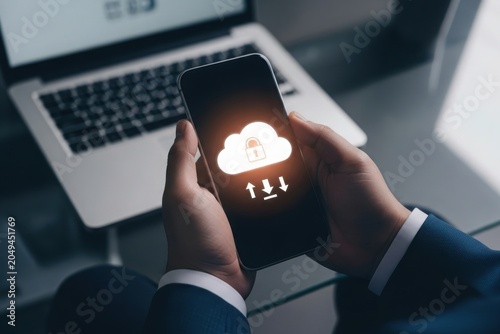 Businessman holding smartphone with cloud storage and security concept on screen in office
