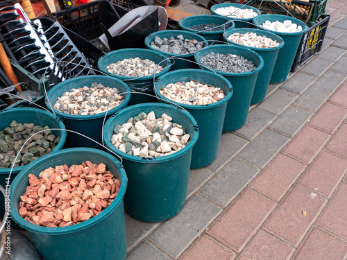 Canvastavla Buckets with decorative stones outside garden supply store