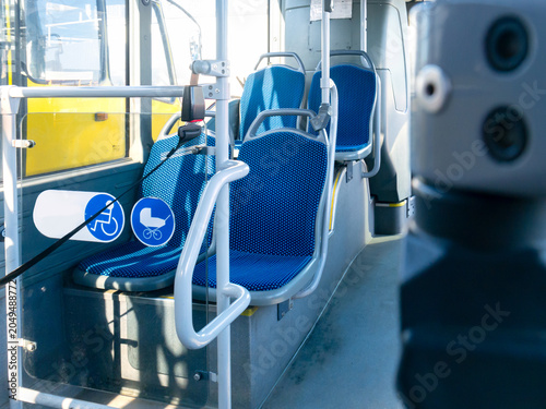 Obraz na plátne Empty city bus interior with blue seats