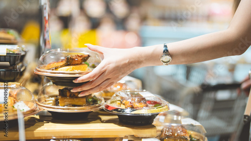 Young adult asian single woman customer choosing ready meals cooked food from shelf at asia supermarket