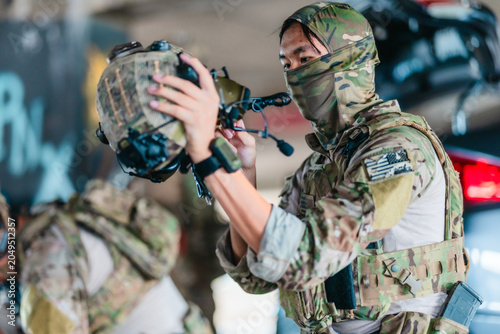 Cuadro en lienzo Tactical operator prepares and adjusts ballistic helmet and combat gear before m