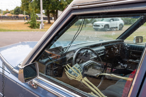 Canvas Print Skeleton passenger holding a tarot card inside a vintage blue hearse style vehic