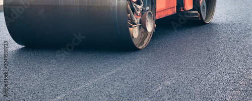 Konstfotografi Asphalt Paving Machinery Conducts Road Repair in Urban Area Under Clear Blue Sky