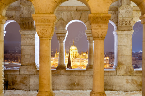 Bild auf Leinwand Hungarian Parliament Building at Night Framed by Fisherman's Bastion Arches in W