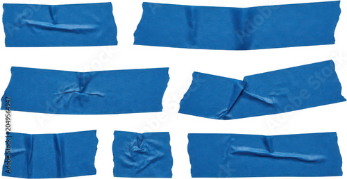 Collection of torn blue painter's tape pieces with visible creases and textures arranged across a white surface blue tape painters tape adhesive tape masking tape torn tape