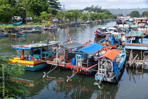 High-angle view of colorful traditional wooden fishing boats moored along a river canal in Cilacap, Indonesia.