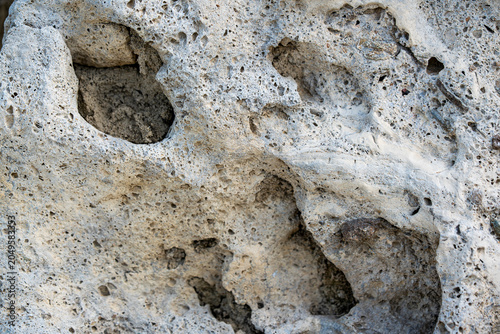 Tableau sur toile Porous tuff stone texture with natural weathering and erosion patterns, Close-up of porous tuff stone showing natural cavities, erosion features and weathered mineral texture