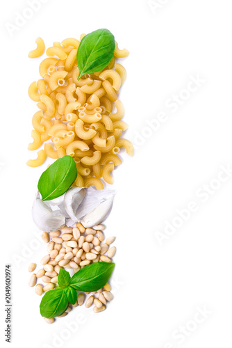 Pesto sauce ingredients with Italian pasta on white background. Top view of raw macaroni, fresh basil leaves, garlic and pine nuts with copy space.