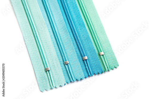 Set of Four Blue and Teal Gradient Zippers Arranged Diagonally on a White Background for Sewing, Tailoring, and Fashion Design Projects
