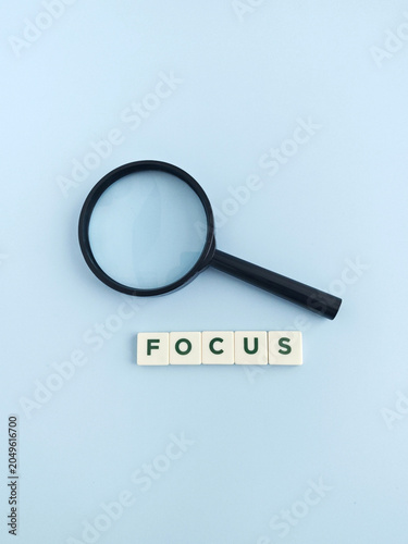 Magnifying glass and focus word showing research and analysis
