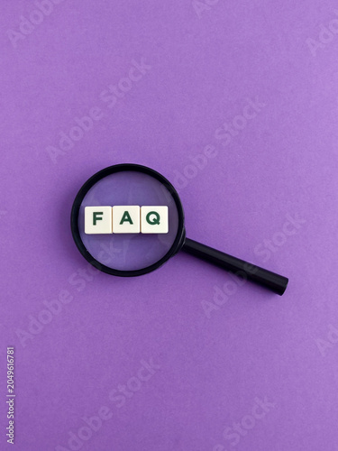 Magnifying glass finding faq letters on purple background