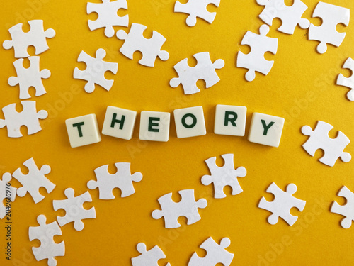 Theory word with puzzle pieces on yellow background