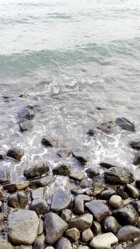 Calming Sea View Background with Beach Waves Washing Smooth Rocks