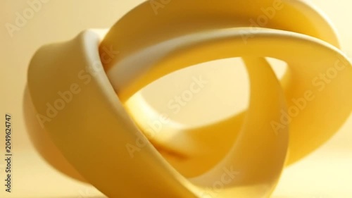 Abstract yellow sculpture with smooth curves on a soft, warm background