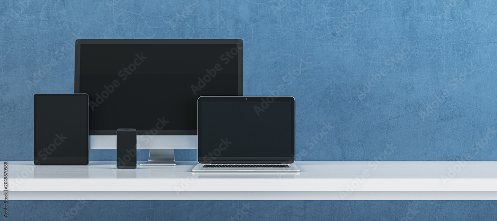 Obraz premium Modern digital device set featuring computer monitor, laptop, tablet and smartphone arranged on clean desk against textured blue background for technology branding. 3D Rendering